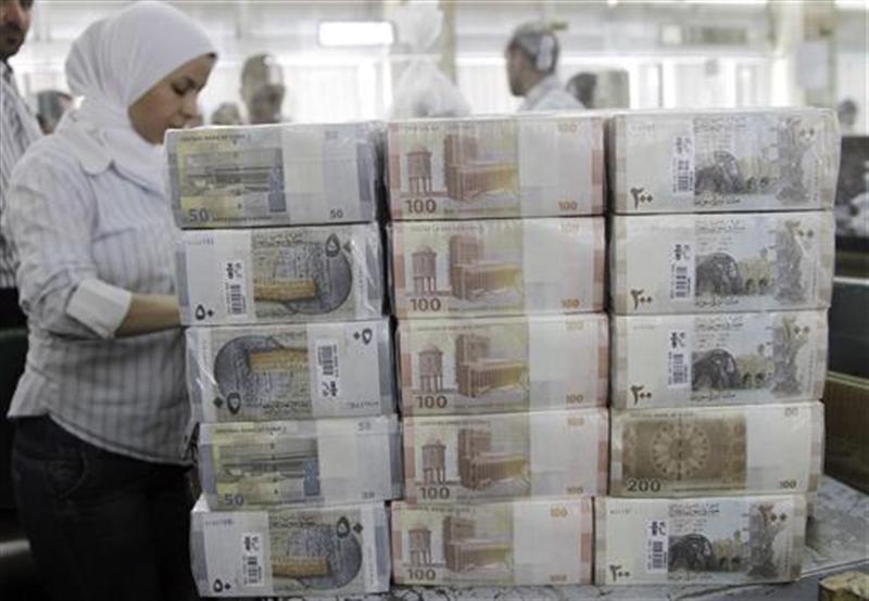 Los nuevos billetes sirios se ven en la pantalla en el banco central en Damasco